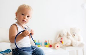 A toddler holds a stethoscope
