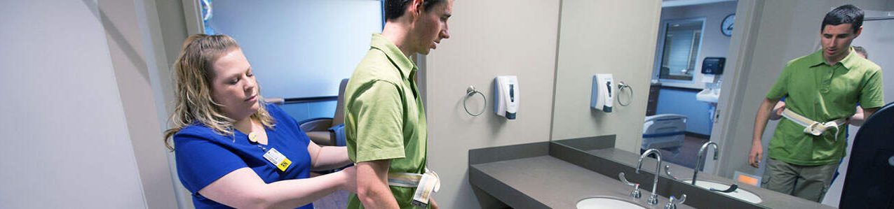 A colleague helps a patient stand