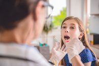 A provider takes a swab sample from a female child