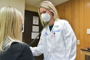 Laura E. Glueck, DO examines a patient