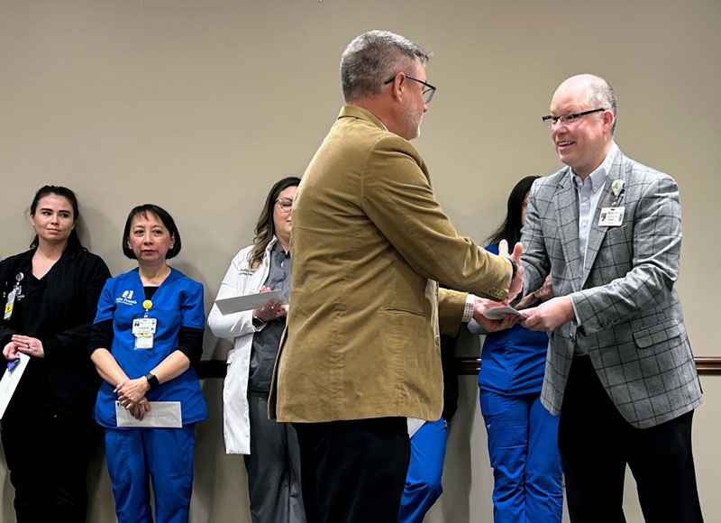 Saint Francis President and CEO Justin Davison presents an award to a Grateful Patient honoree.