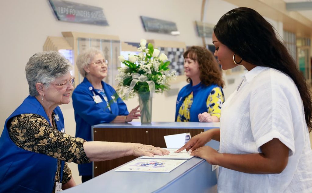 Volunteers greet a patient in the Saint Francis Medical Center lobby