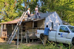 Saint Francis Foundation and Facilities volunteers work on Rae Shaw-Johnson's roof