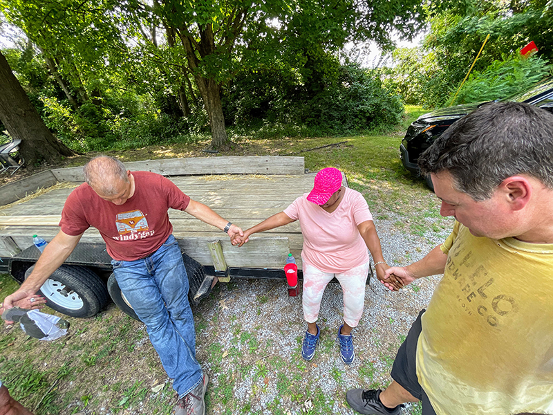 Foundation colleagues Jimmy Wilferth and Stacy Huff pray with Rae Shaw-Johnson