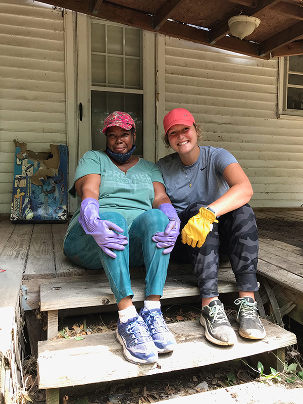 Rae Shaw-Johnson and volunteer Chrissy Wilferth pause working to pose on Johnson's porch