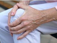 A woman holds her sore knee