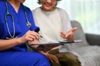 A nurse helps a patient fill out a form