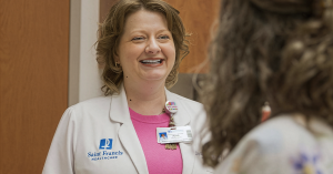 April Ostendorf-Morris, MSN, APRN, ACNS-BC visits with a patient