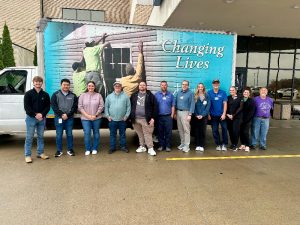 Workers stand outside a truck loaded with boxes from the 2025 St. Elizabeth Food Drive